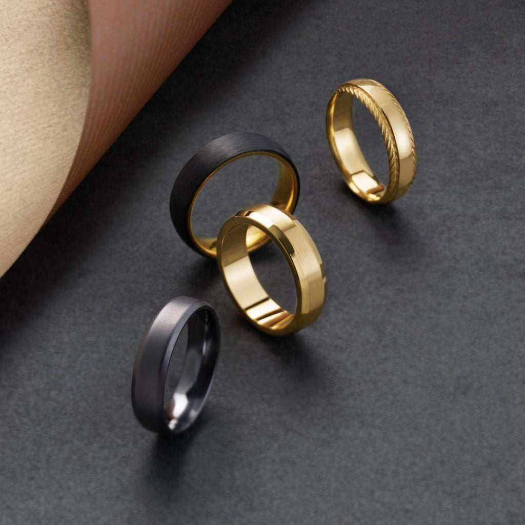 Gold and black wedding bands with textured and polished finishes on dark surface