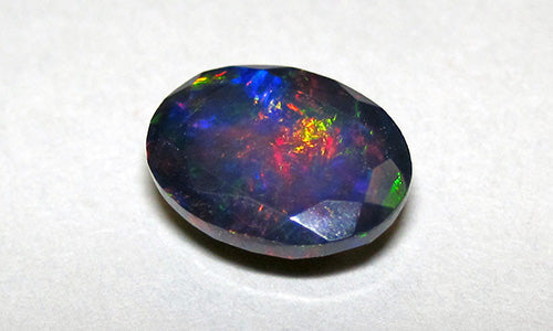 Vibrant black opal gemstone with fiery red, blue, and green flashes, ideal for custom jewelry in Charlotte, NC.