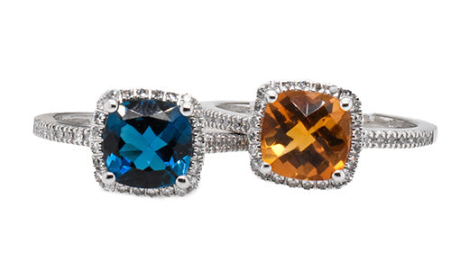 Two cushion-cut gemstone rings with diamond halos, featuring blue and orange stones on white gold bands.