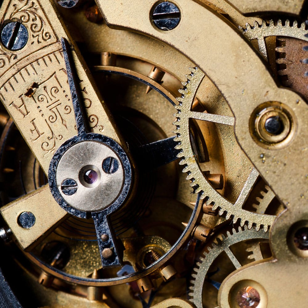 Intricate vintage watch mechanism with gold gears and engraved details, showcasing fine craftsmanship.