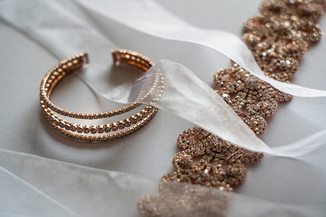Elegant rose gold bracelet and sparkling diamond jewelry on white fabric, perfect for engagement or Indian wedding styles