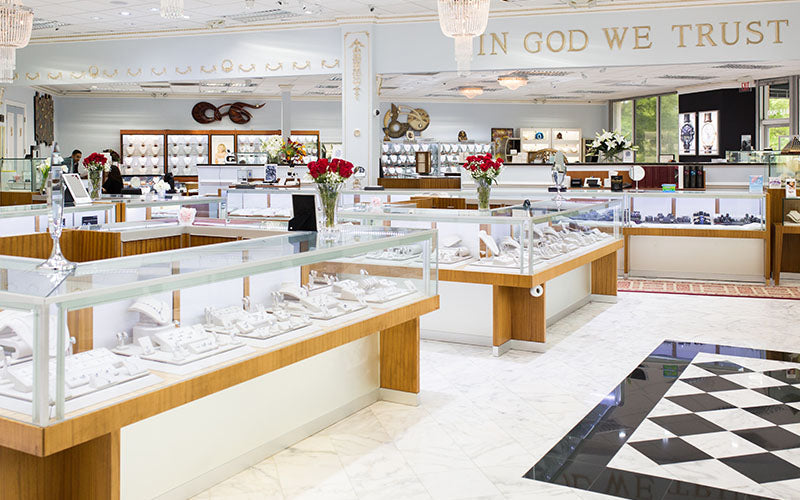 Luxury jewelry store interior with glass display cases, engagement rings, and elegant marble floors in Charlotte, NC